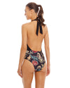 woman wearing black High Neck One Piece features a plunging neckline with mesh panel and halter tie around the neck and a contrasting print bottom has hand beading for added style.