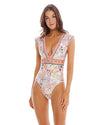 woman wearin a One Piece that features a plunge neckline with an elegant hand beaded design under the bust and cap sleeves